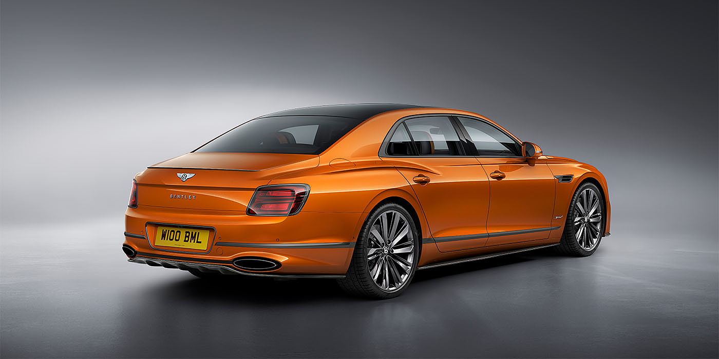Bentley Suomi Bentley Flying Spur Speed in Orange Flame colour rear view, featuring Bentley insignia and enhanced exhaust muffler.