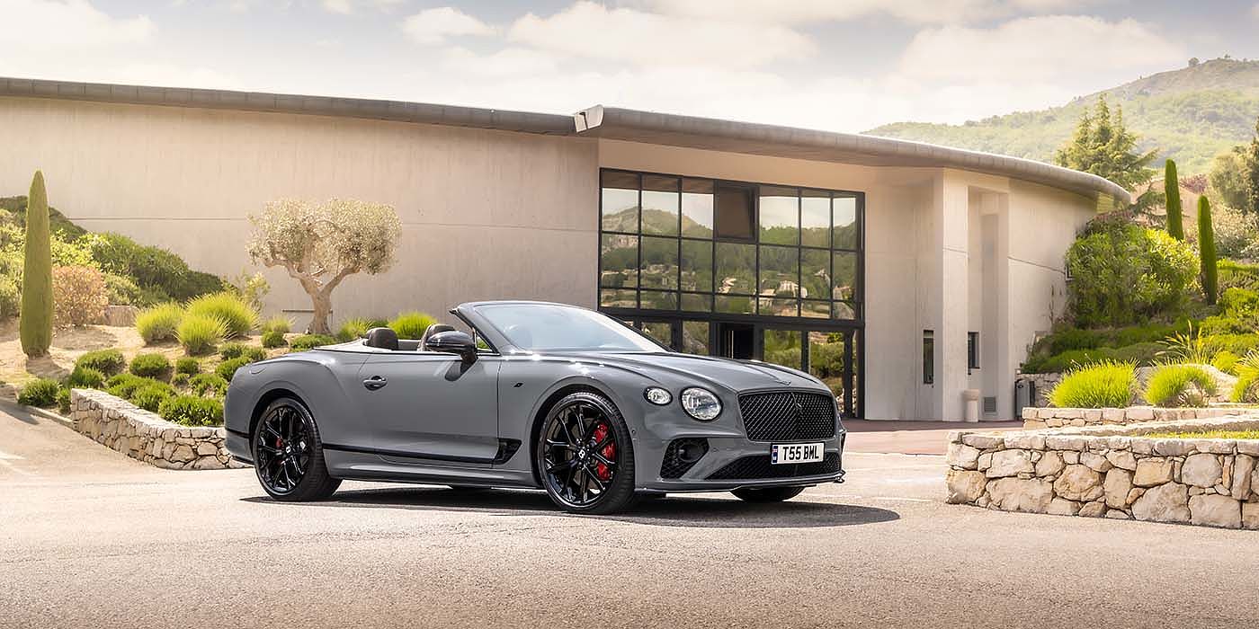 Bentley Suomi Bentley Continental GTC S convertible in Cambrian Grey paint front 34 static near house